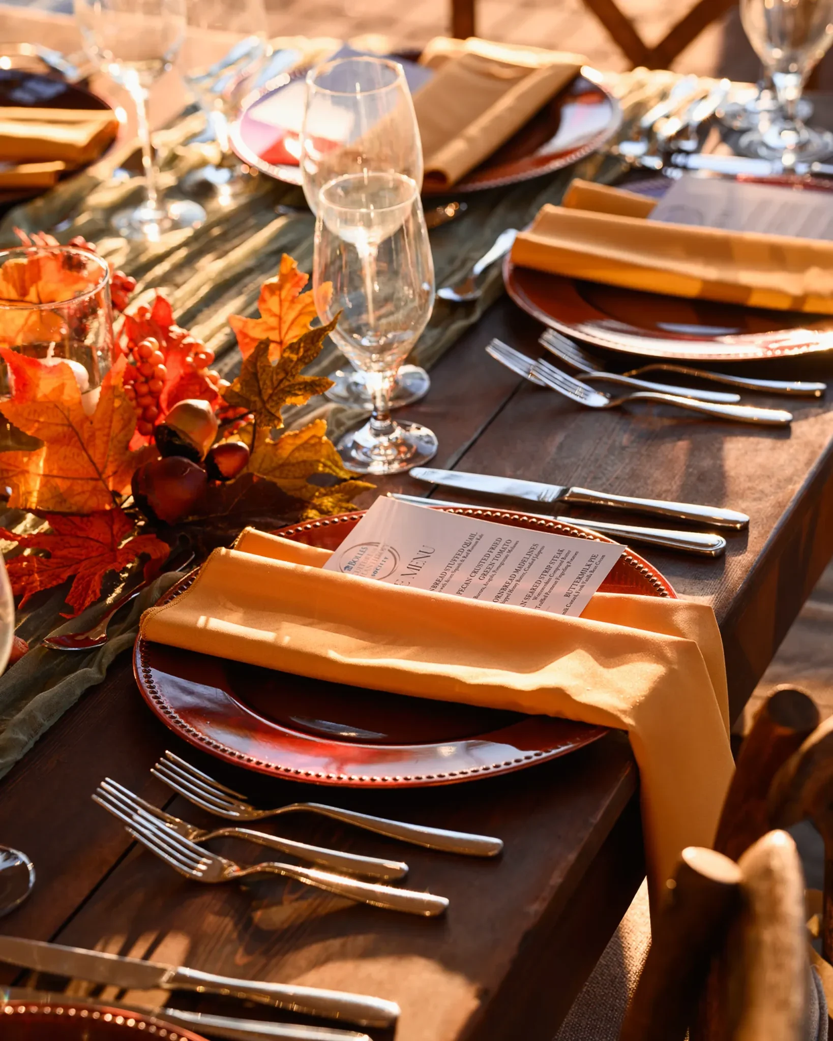 Autumn place setting with dinner menu, charger plate, and leaf runner at the Bolles Harvest Dinner