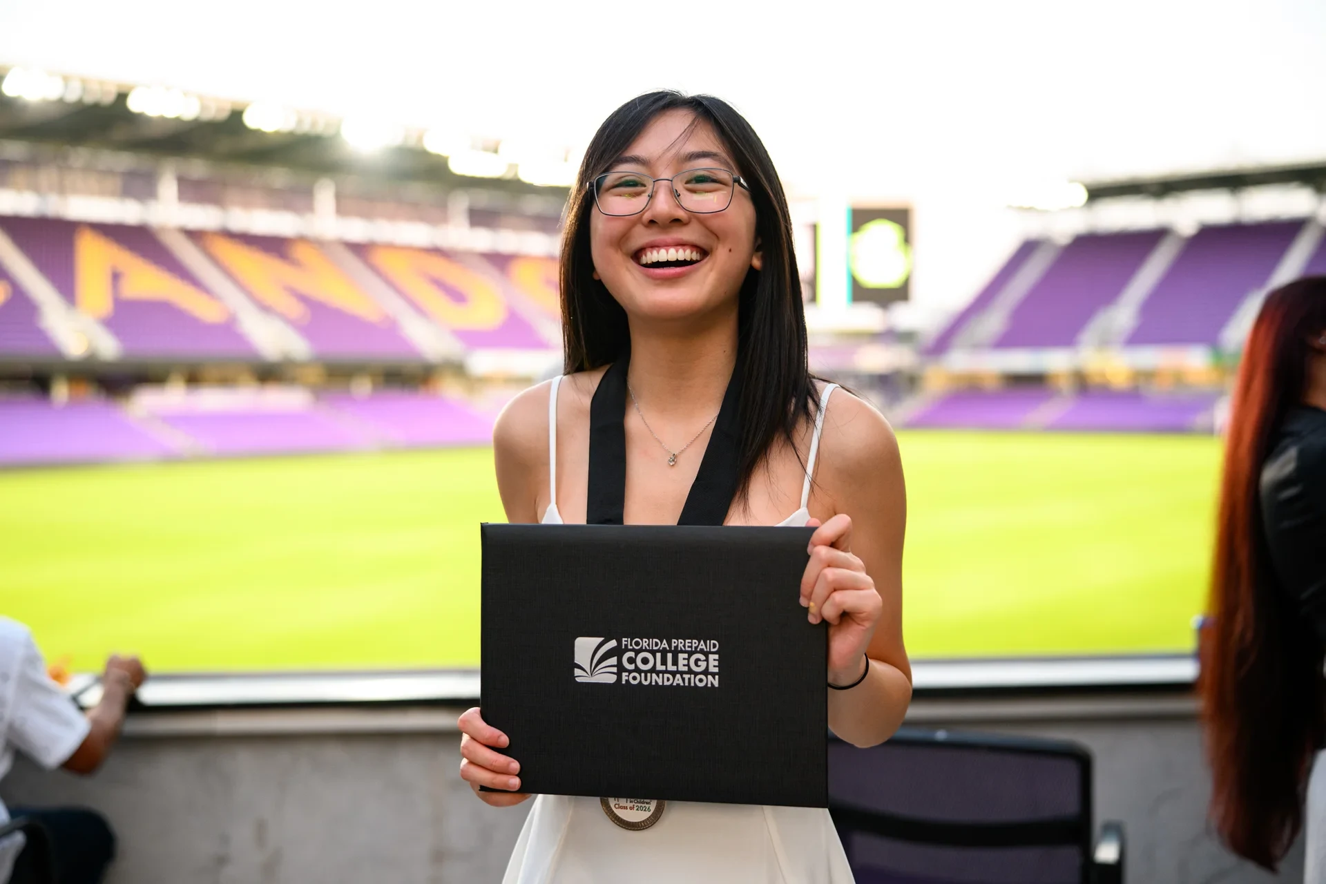 Florida Prepaid College Foundation Class of 2026 scholarship recipient holding her certificate at Inter&Co Stadium in Orlando