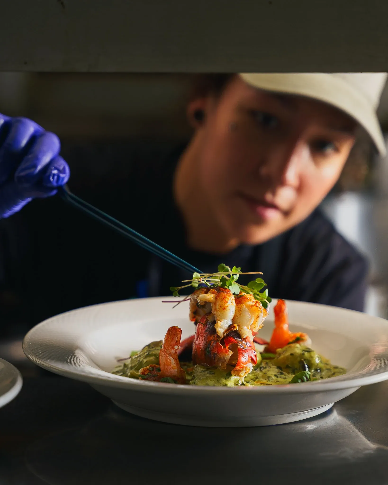 Executive Chef adding microgreens as the finishing touch to a lobster dish at Collage restaurant in St. Augustine