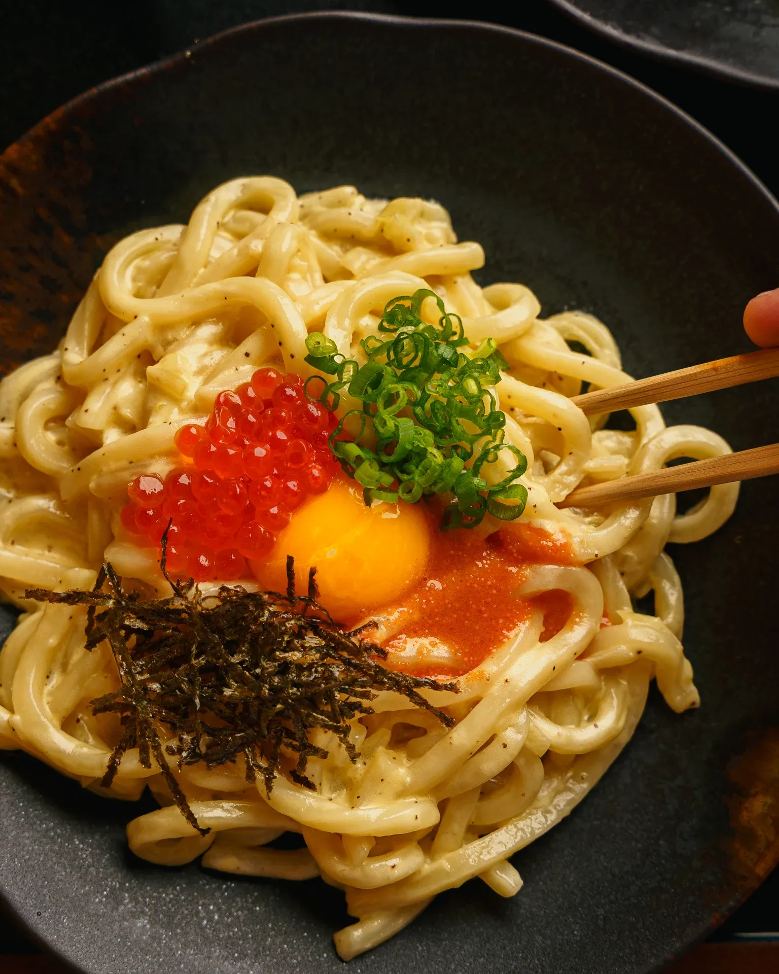 Creamy udon bowl with ikura, egg yolk, nori, and mentaiko