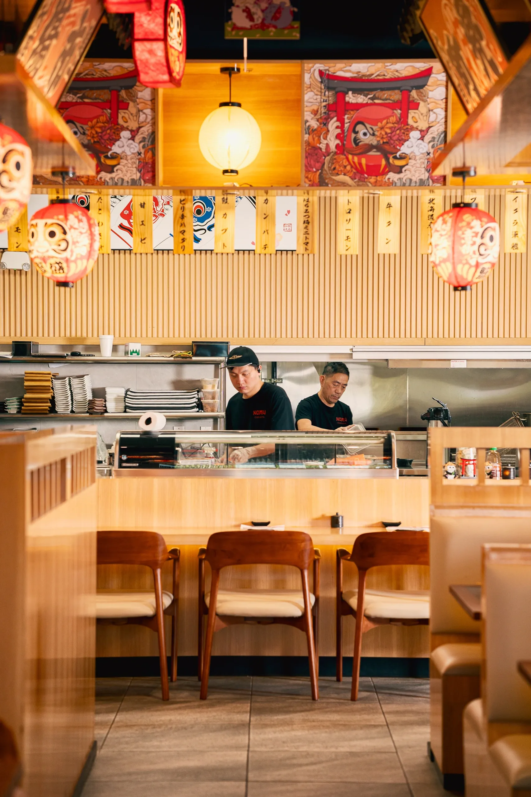 Empty dining room at Nomu Izakaya with chefs in view