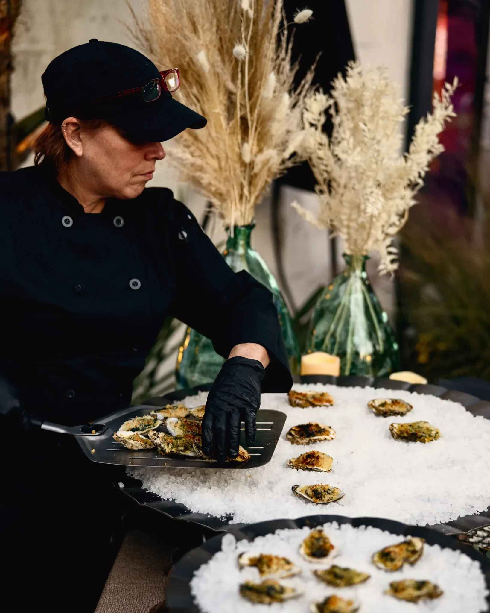 Chef plating roasted oysters on a salt bed at the PRI industry event at Citri San Marco